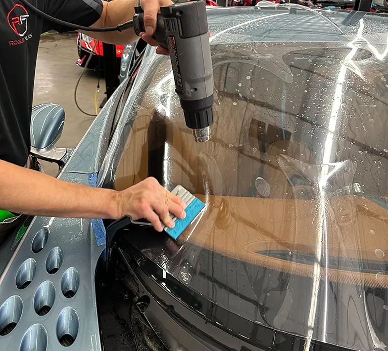 Applying window tint to a car.