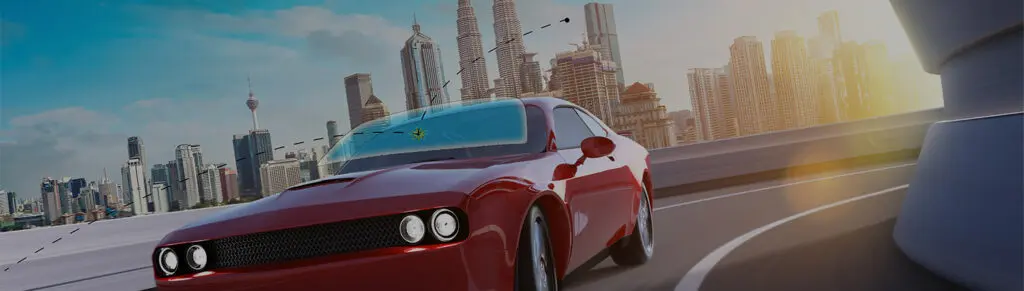 Red car driving through city skyline.