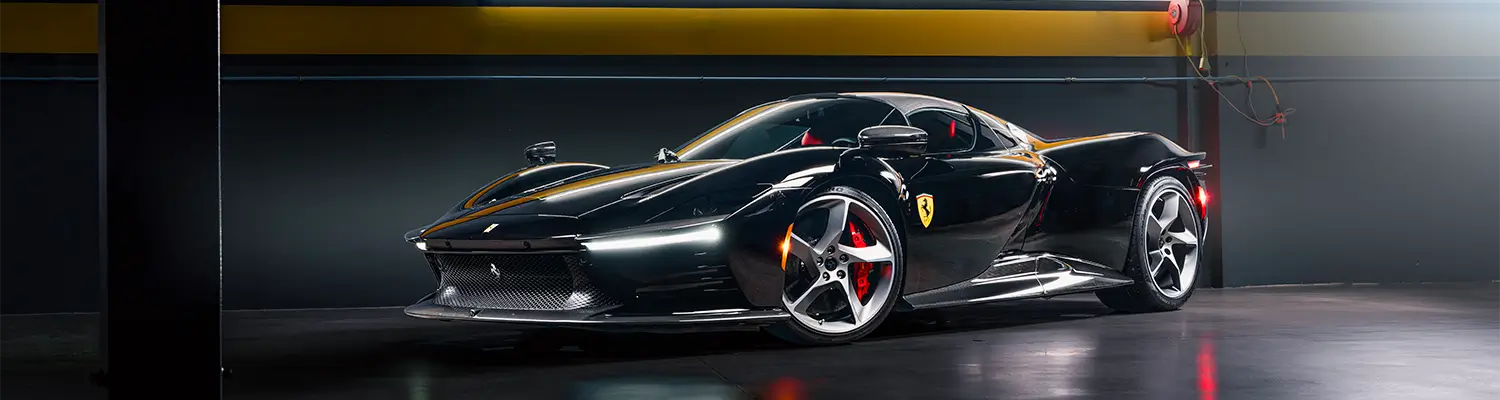 Black Ferrari sports car in garage.